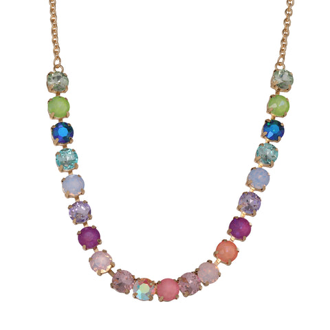 The Tennis Necklace with Multicolor Crystals is a gold-plated statement piece featuring round, vibrant crystals arranged in a symmetrical pattern along the front.