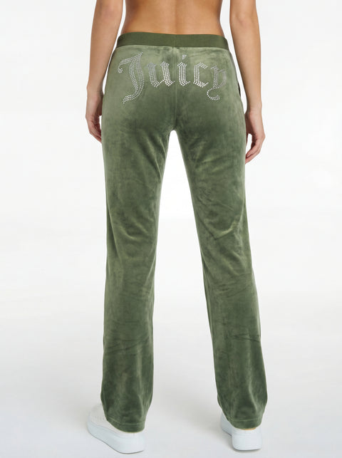 A person wearing OG Big Bling Velour Track Pants—REJUICED in green, featuring "Juicy" rhinestones on the back, stands against a white background. Only the lower back and legs are visible. Machine washable for easy care.