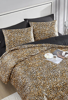 Leopard print bedding set on a bed with black pillows and white nightstands.