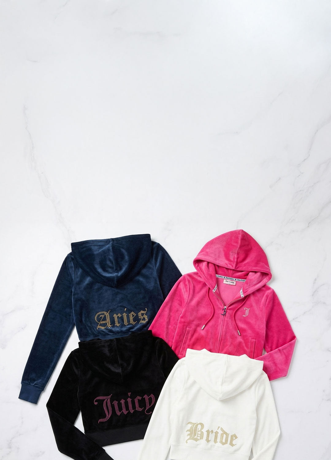 Three tracksuit tops with 'Aries', 'Juicy', and 'Bride' text and a pink tracksuit top with a 'J' initial on the front on a white background